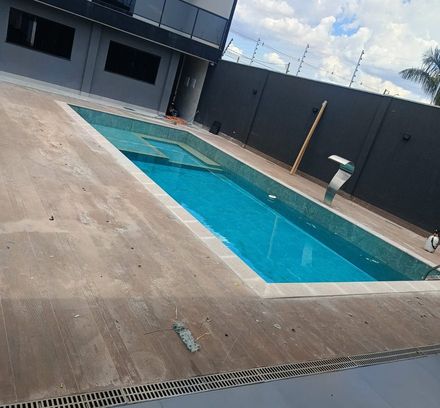 área de piscina com piso de concreto cru ao redor, antes da instalação